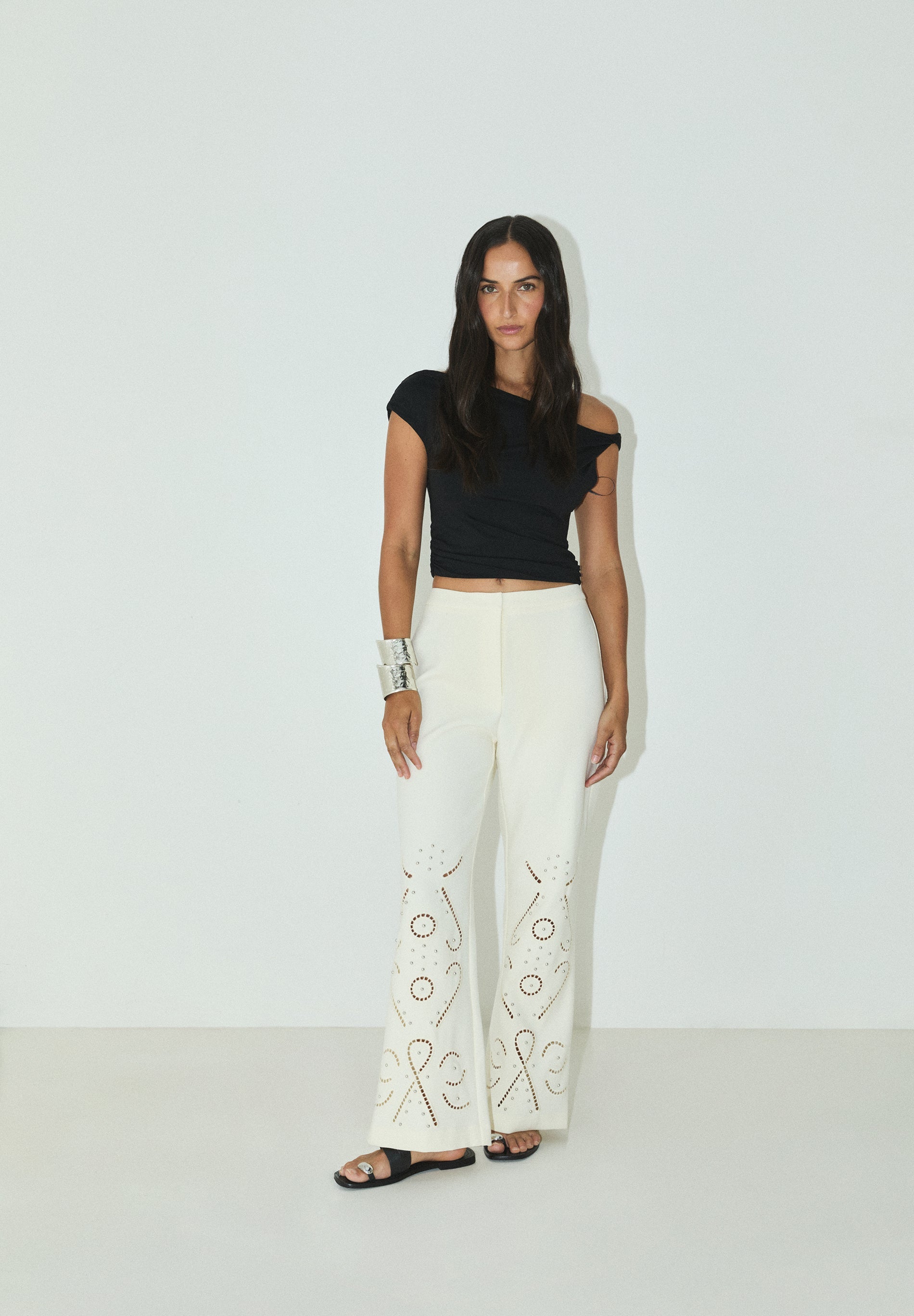 CALÇAS COM PORMENORES PERFURADOS