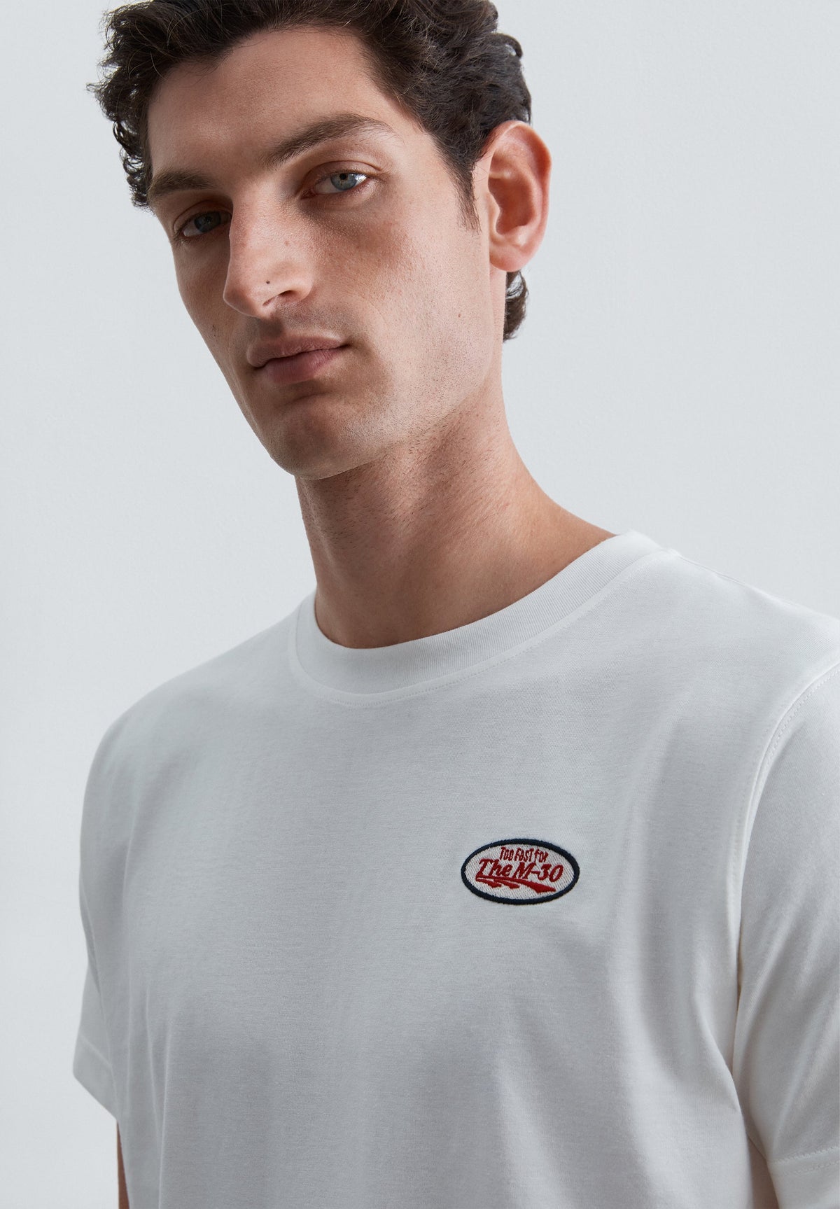 T-SHIRT COM PADRÃO E DETALHE DE REMENDO
