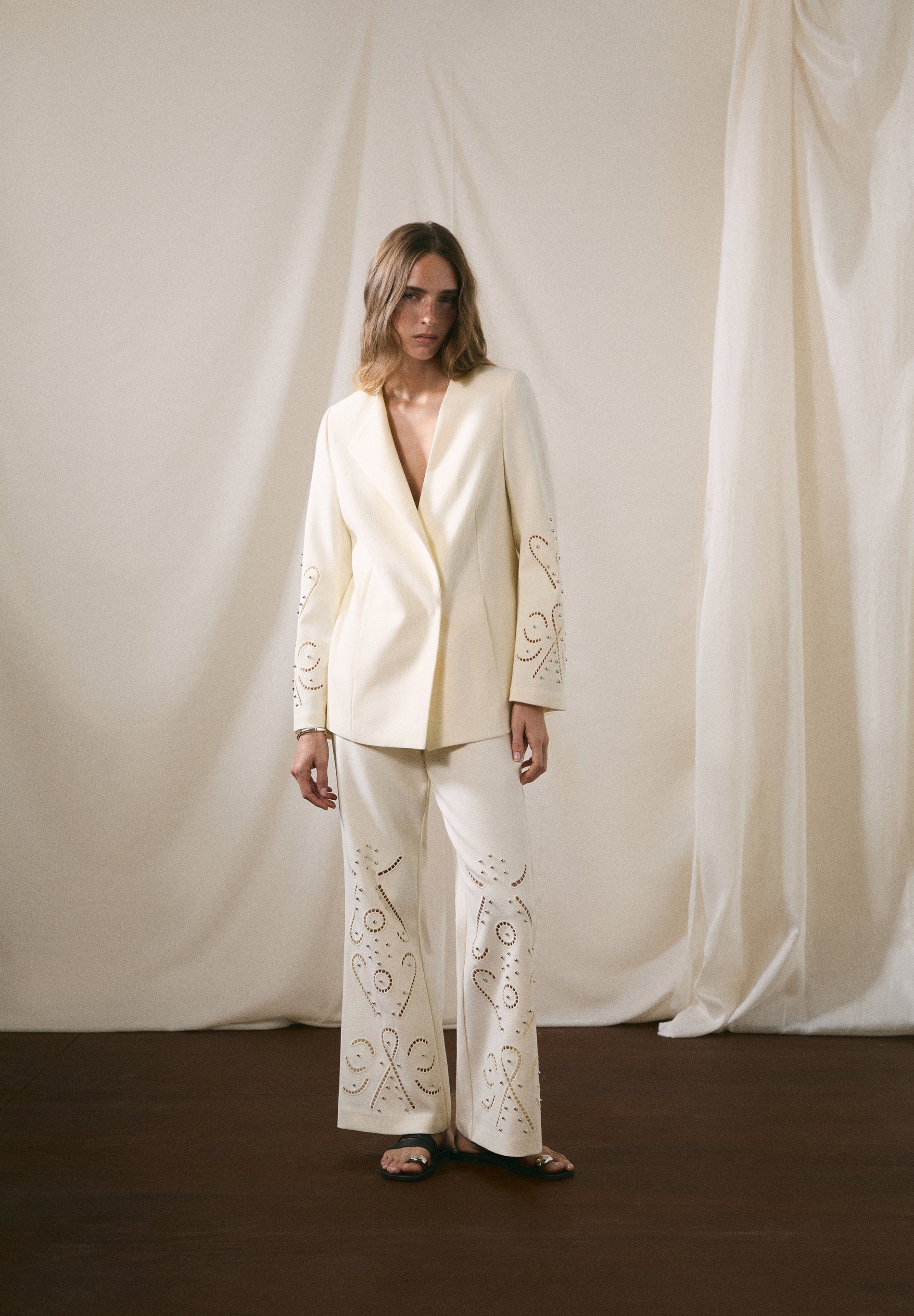 CALÇAS COM PORMENORES PERFURADOS